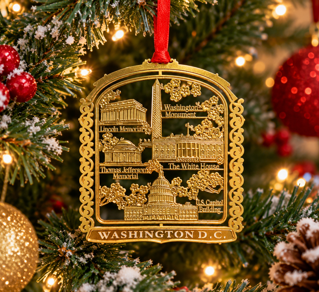Gold-tone panorama Christmas ornament with Washington D.C. landmarks and red hanging ribbon
