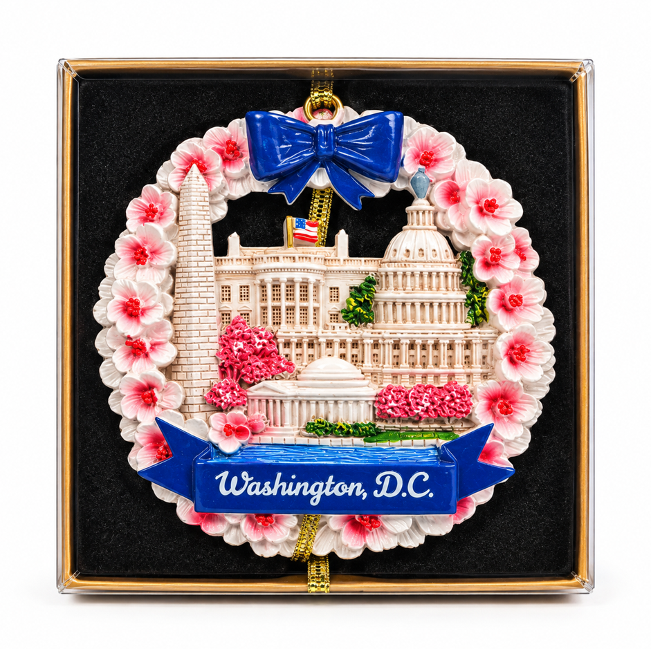 Ceramic Washington, D.C. ornament with blue bow, pink blossoms, and wreath in gift box